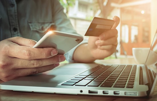 une personne utilise sa carte de crédit pour faire un paiement en ligne 5 Hacks to Help Earn Soaring Airline Miles—And Travel Points!
