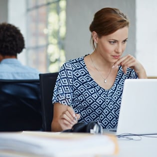 Une femme d’affaires travaille au moyen de son ordinateur portable au bureau