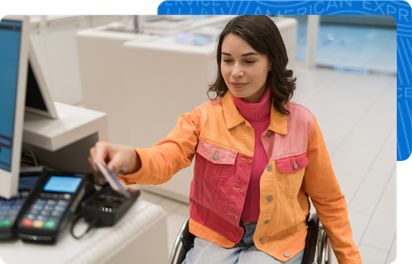 A woman in a wheelchair paying with credit card at checkout lane