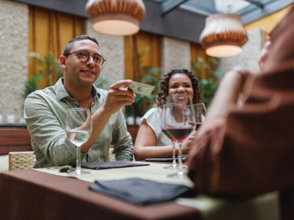 Mann bezahlt im Restaurant mit Kreditkarte.
